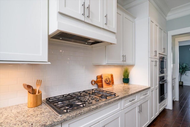 kitchen with stainless steel appliances, light stone counters, extractor fan, and white cabinets