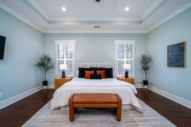 bedroom featuring a raised ceiling, dark wood finished floors, and baseboards