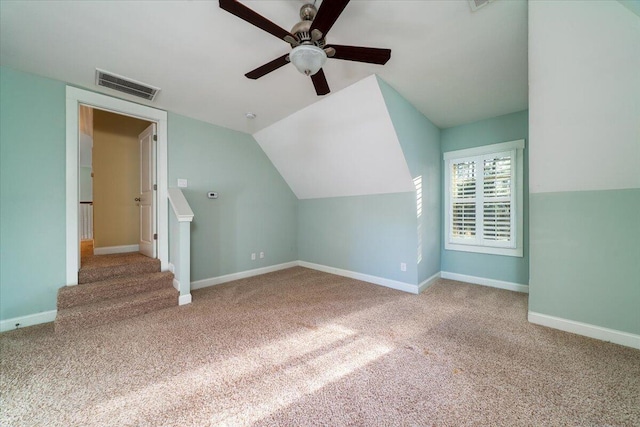 additional living space with baseboards, visible vents, a ceiling fan, light colored carpet, and lofted ceiling