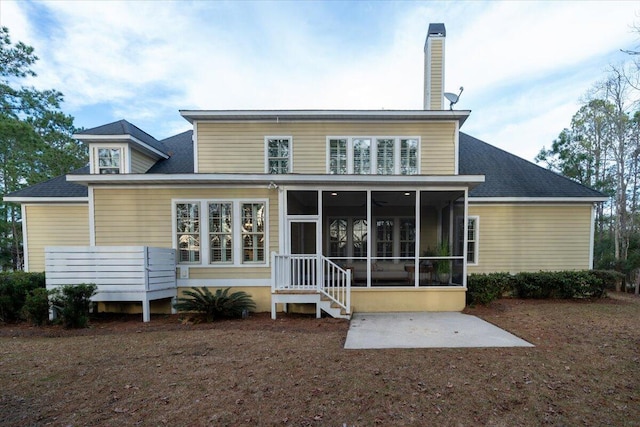 back of property featuring a sunroom and a chimney