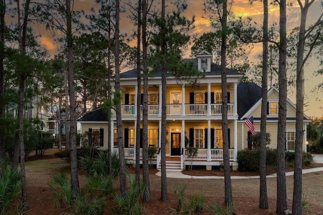 rear view of property with a porch and a balcony