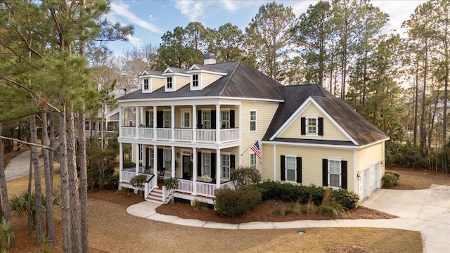 view of front of home featuring a balcony, driveway, a garage, and a porch