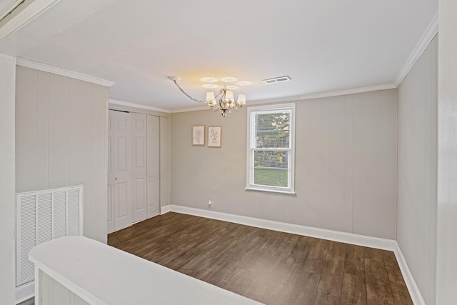 unfurnished room with wood finished floors, a chandelier, baseboards, and ornamental molding