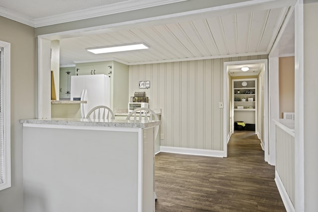 kitchen featuring white fridge with ice dispenser, dark wood-style floors, built in shelves, light countertops, and crown molding