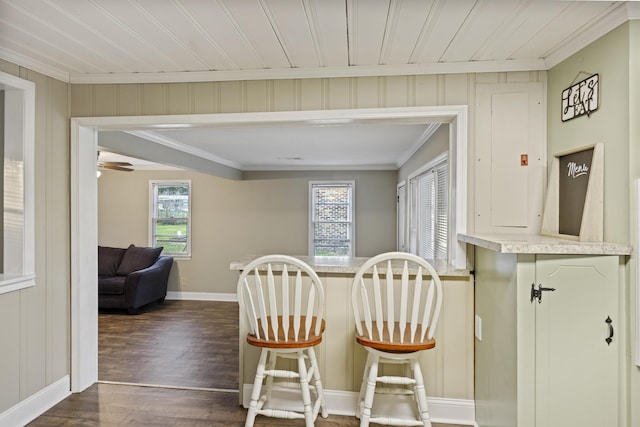dining room featuring dark wood-style floors, crown molding, and baseboards