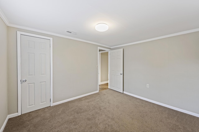 unfurnished bedroom featuring carpet floors, baseboards, and crown molding