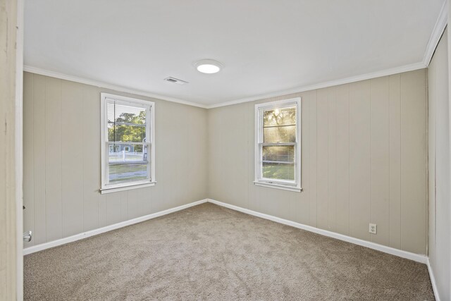 unfurnished room with carpet flooring, ornamental molding, and baseboards