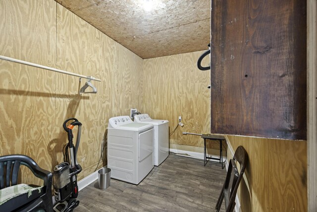 washroom with washer and dryer, dark wood-type flooring, and baseboards