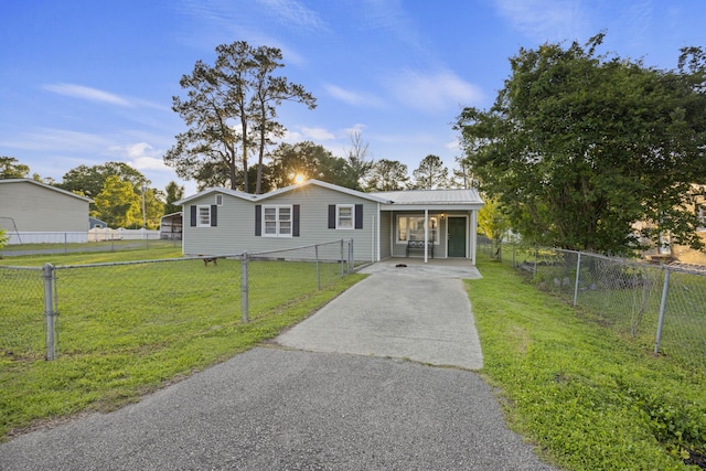 manufactured / mobile home with asphalt driveway and metal roof