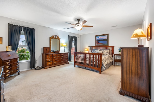 carpeted bedroom with a textured ceiling and ceiling fan