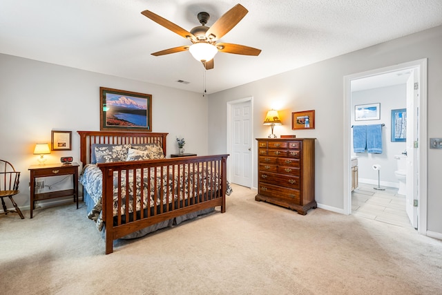 carpeted bedroom with ceiling fan, a textured ceiling, and ensuite bath