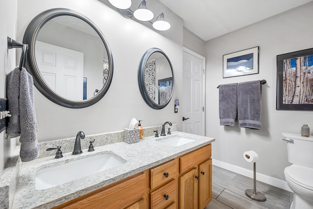 bathroom with vanity, toilet, and wood-type flooring