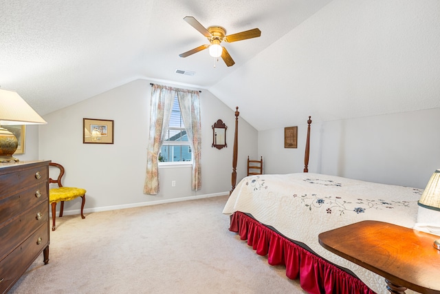 bedroom featuring light carpet, a textured ceiling, vaulted ceiling, and ceiling fan