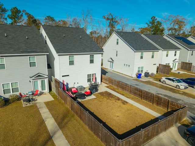 rear view of property featuring cooling unit, a lawn, and a patio