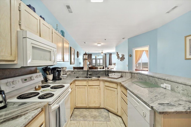 216 W Arctic Ave Unit 9, Folly Beach, SC 29439 - kitchen featuring white appliances, a sink, light brown cabinets, light stone counters, and a peninsula