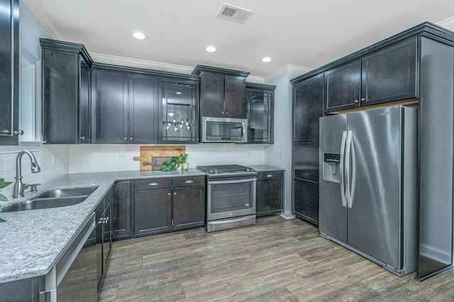 kitchen featuring visible vents, dark wood-type flooring, a sink, stainless steel appliances, and crown molding