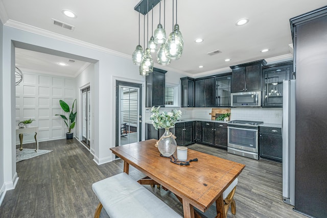 kitchen featuring visible vents, dark wood-type flooring, ornamental molding, appliances with stainless steel finishes, and decorative backsplash