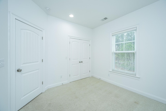 unfurnished bedroom featuring recessed lighting, visible vents, baseboards, and carpet