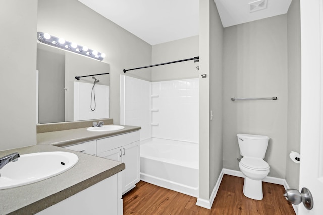 full bathroom featuring shower / bath combination, vanity, hardwood / wood-style floors, and toilet