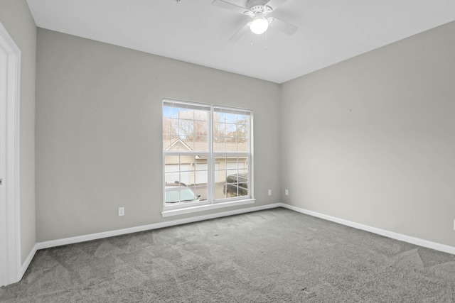 empty room featuring ceiling fan and carpet