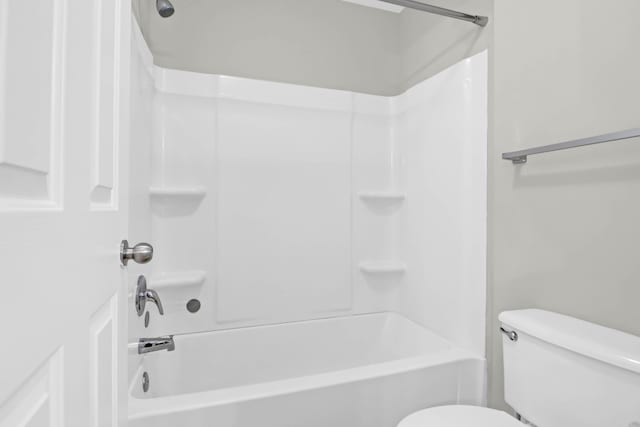 bathroom with tub / shower combination and toilet