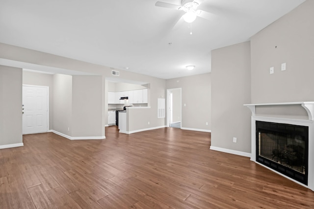 unfurnished living room with hardwood / wood-style flooring and ceiling fan