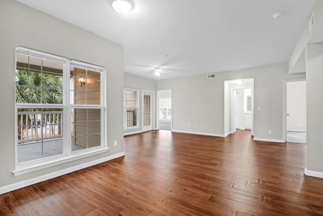 unfurnished living room with ceiling fan and dark hardwood / wood-style flooring