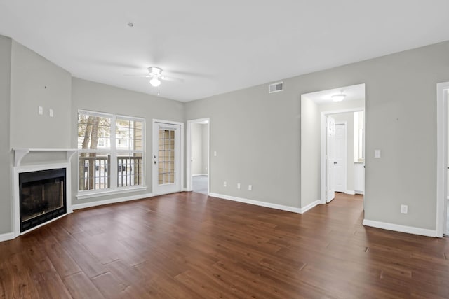 unfurnished living room featuring dark wood-type flooring and ceiling fan