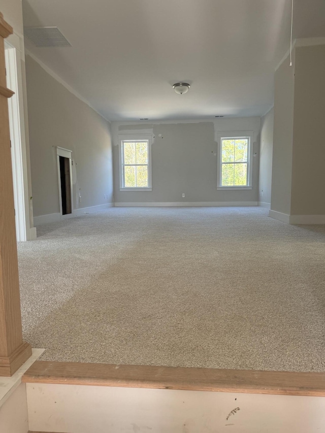 carpeted empty room with a healthy amount of sunlight and baseboards