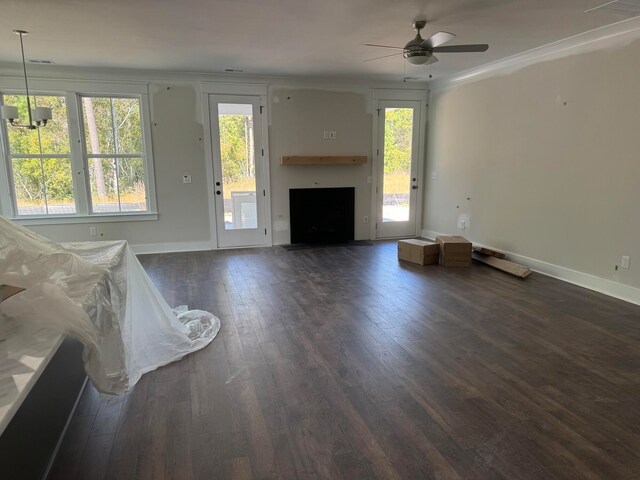 unfurnished living room with dark wood-style floors, ceiling fan, and baseboards