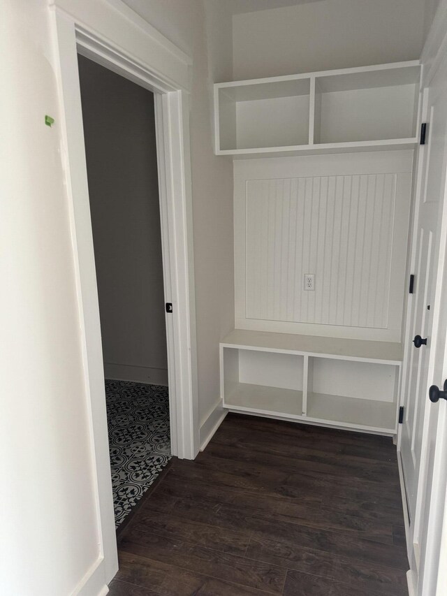 mudroom with dark wood-style floors and baseboards