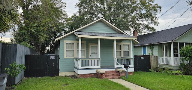 bungalow-style home with a porch and a front lawn