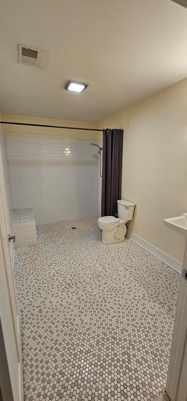 bathroom featuring toilet and a shower with curtain