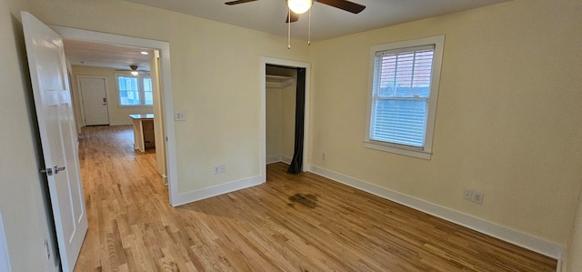 unfurnished bedroom with light hardwood / wood-style floors, multiple windows, ceiling fan, and a closet