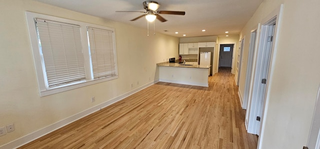 kitchen with white cabinets, ceiling fan, light wood-type flooring, and kitchen peninsula