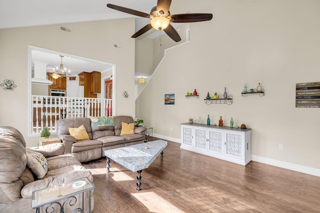 living room with dark wood-type flooring, lofted ceiling, and ceiling fan with notable chandelier