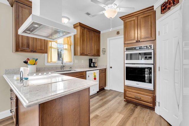 kitchen featuring white appliances, sink, kitchen peninsula, island range hood, and crown molding