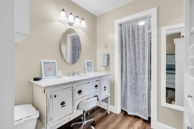 bathroom with toilet, vanity, wood-type flooring, and walk in shower