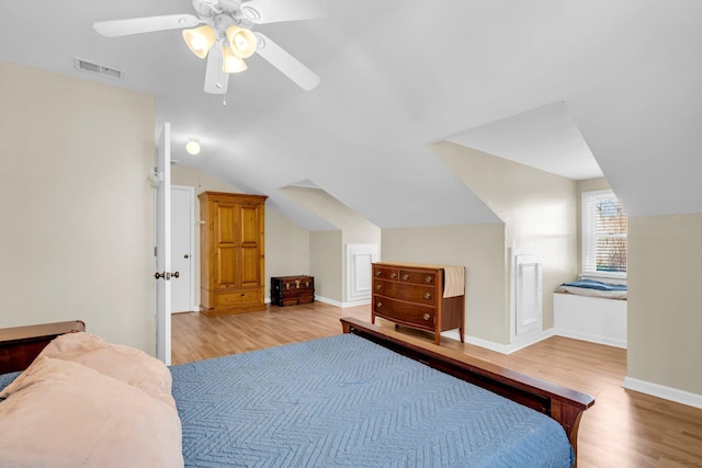 bedroom with ceiling fan, vaulted ceiling, and light hardwood / wood-style floors