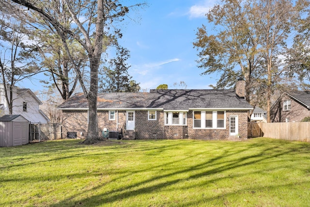 rear view of house with a storage unit and a yard