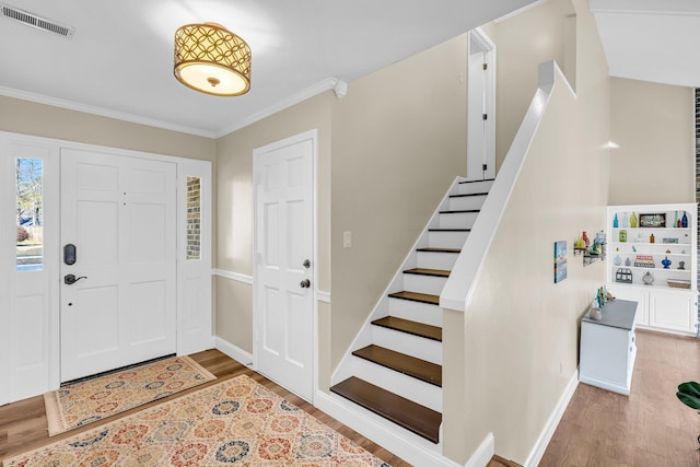 foyer with light hardwood / wood-style flooring and crown molding