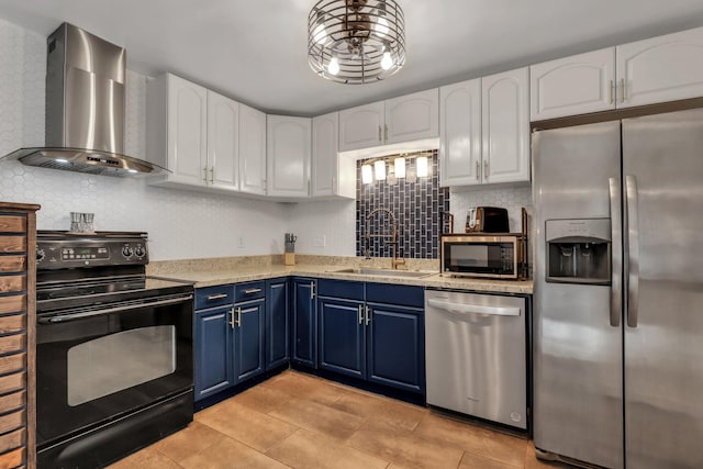 kitchen with white cabinets, stainless steel appliances, wall chimney range hood, and blue cabinets