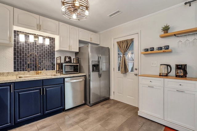 kitchen with white cabinets, appliances with stainless steel finishes, tasteful backsplash, and sink