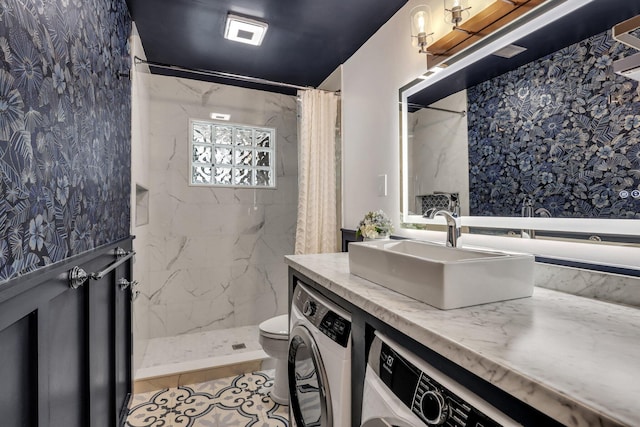 bathroom featuring tile patterned flooring, washer / dryer, toilet, and curtained shower