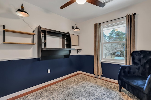 sitting room with hardwood / wood-style floors and ceiling fan