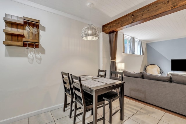 tiled dining room featuring beam ceiling