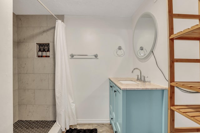 bathroom featuring a textured ceiling, vanity, and walk in shower