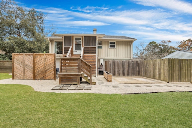 rear view of property with a patio, a lawn, and a sunroom