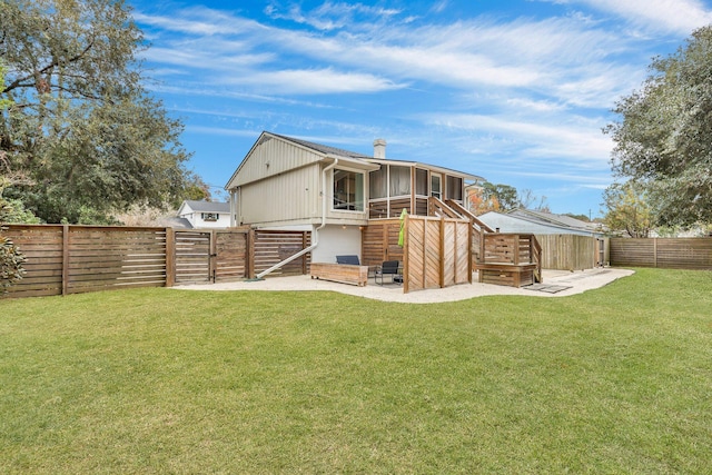 rear view of house featuring a sunroom and a yard