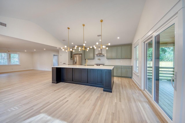 kitchen featuring stainless steel fridge with ice dispenser, light wood-type flooring, light countertops, lofted ceiling, and an inviting chandelier